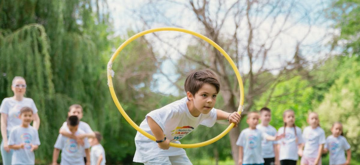 Kids enjoying a summer day playing with hula hoops in a park, showcasing friendship and fun.