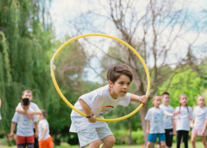 Kids enjoying a summer day playing with hula hoops in a park, showcasing friendship and fun.
