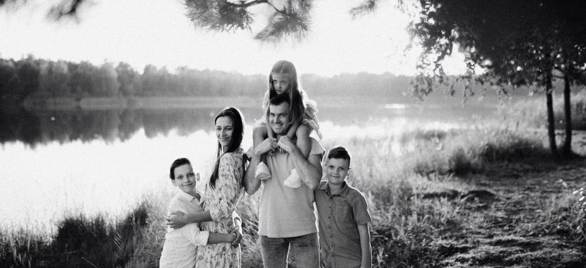 A joyful family enjoying time by the lake in a serene setting.