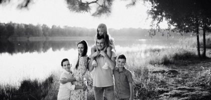 A joyful family enjoying time by the lake in a serene setting.