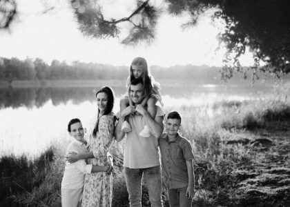 A joyful family enjoying time by the lake in a serene setting.